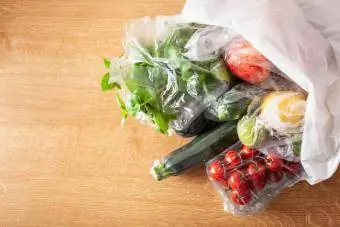 Produzieren Sie in Plastiktüten auf einem Holztisch