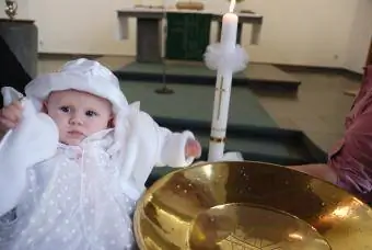 Vaftiz edilmek üzere yazı tipinin yanındaki bebek
