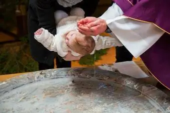 Rahip vaftiz yazı tipinde bebeği vaftiz ediyor