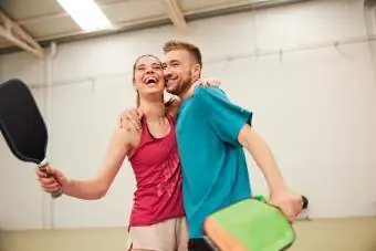 Un jeune couple s'embrassant sur le terrain de pickleball