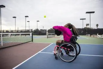 Uma mulher em uma cadeira de rodas jogando pickleball