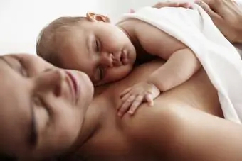 Kūdikių dukra miega ant motinos krūtinės
