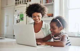 äiti ja tytär käyttävät kannettavaa tietokonetta yhdessä