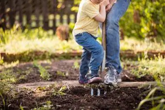 Pigebarn hjælper sin mor i haven