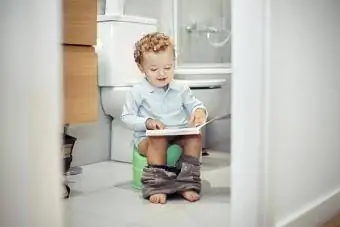کودکی که روی توالت نشسته است