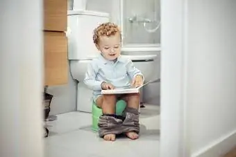 Niño sentado en el baño