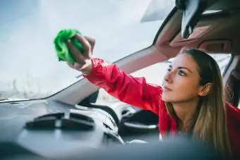 žena umýva okná auta