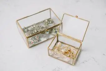 Kotak barang kemas lutsinar dengan perhiasan emas
