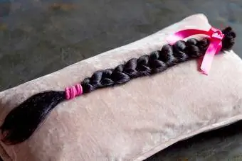 Donación de trenza de cabello castaño sobre una almohada