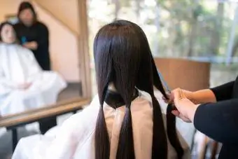 Wanita membelah dan memotong rambut untuk sumbangan