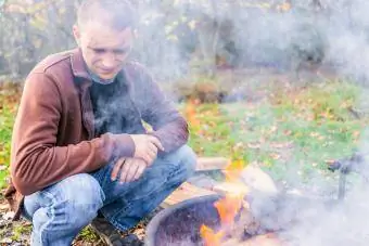 čovjek uz logorsku vatru