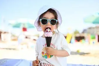 Bayi perempuan kecil yang cantik makan aiskrim