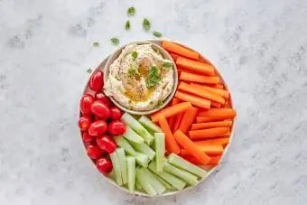 hummus met kerstomaatjes, wortel en komkommerreepjes