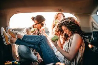 Jóvenes amigos divirtiéndose en el maletero del coche