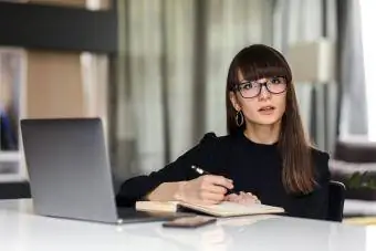 Pengusaha wanita dengan laptop duduk di meja kantor