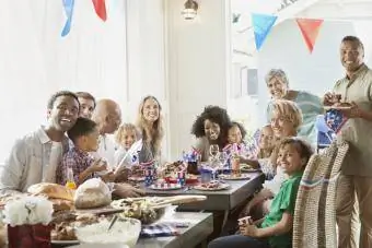 Keluarga dan teman-teman di meja makan merayakan tanggal 4 Juli