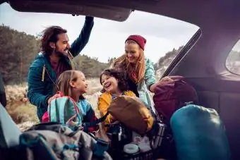 Junge Familie holt die Campingutensilien aus dem Auto