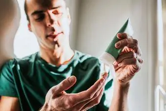 En man applicerar lotion på sin hand