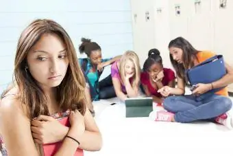 Teenager-Mädchen schikanieren einen Klassenkameraden mit einem Tablet im Internet