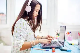 Teenager benutzt Laptop mit Kopfhörern
