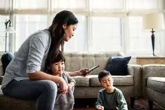 Madre che usa lo smartphone con i bambini presenti