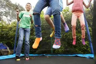 ልጆች በ trampoline ላይ እየዘለሉ ነው።