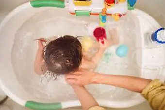 Mamma badar för lilla bebisen i badkaret