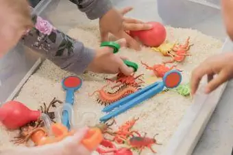 Crianças irreconhecíveis brincam em caixa sensorial
