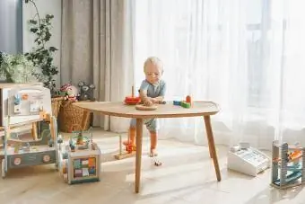 پسر بچه در حال بازی با اسباب بازی های چوبی