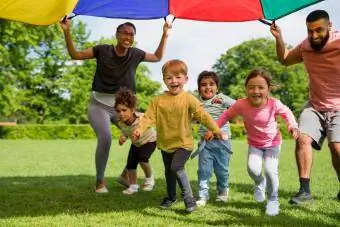 Niños jugando con un paracaídas en un preescolar