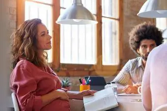 कार्यालय में सहकर्मियों के साथ गर्भवती व्यवसायी महिला