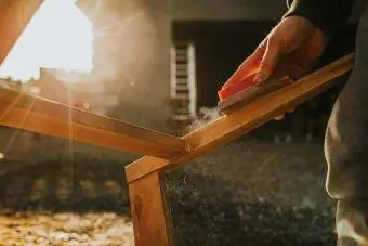 Muž broušení a restaurování teakového nábytku