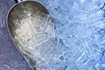 Senduk duduk dalam timbunan ais dari mesin ais