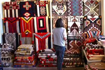 Seorang pelawat mengagumi permaidani asli Amerika yang dibuat oleh penenun dari Negara Navajo - Editorial Getty