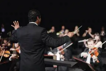 Maestro acenando com a batuta sobre a orquestra