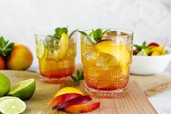 Cocktail med persika, mynta och lime och isbitar