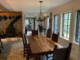 Country summer kitchen na may wood burning stove, chandelier at malaking wooden dining table