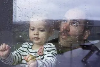 El pare i la filla observen la pluja des de dins