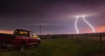 Kravas automašīna apstājās uz ceļa, kamēr tālumā iespēra zibens