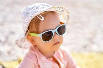 Μικρό κορίτσι με γυαλιά ηλίου στην παραλία