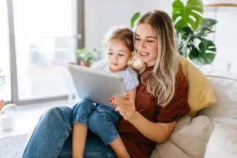 Madre e figlia che utilizzano insieme una tavoletta digitale -