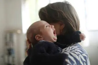 madre sosteniendo al bebé bostezando
