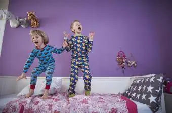 Energiska barn hoppar på sängen