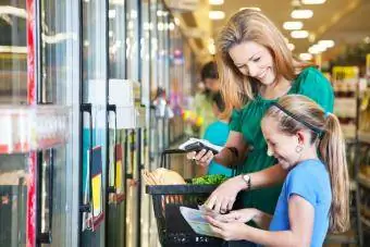 Mãe e filha usando cupons no supermercado