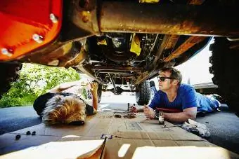 Ayah dan anak bekerja di bawah kereta