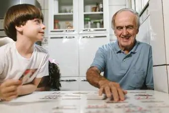 Farfar och barnbarn spelar koncentration med kortlek