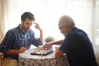 Ældre far og voksen søn spiller skak