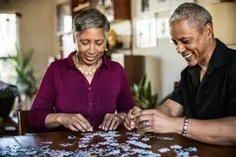 Couples de personnes âgées faisant un puzzle