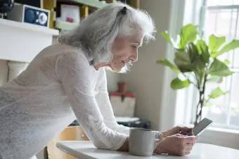 yaşlı qadın telefonunda trivia oyunları oynayır