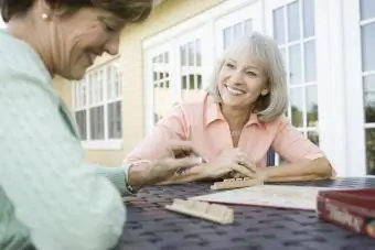 Arkadaşlarla Kelimeler veya Scrabble benzeri bir oyun oynayan iki kıdemli kadın
